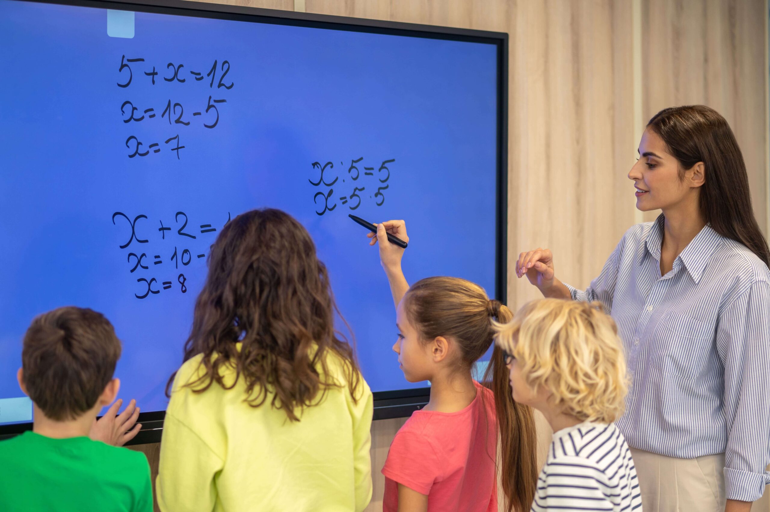 children writing blackboard attentive teacher watching min 1 scaled